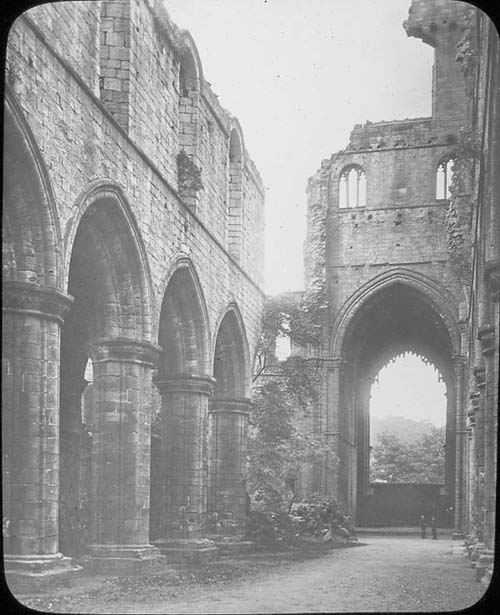 View of the church at Kirkstall Abbey showing debris left by the partial collapse of the tower in 1779 with vegetation. 