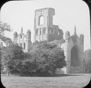 Photograph of the church at Kirkstall Abbey taken from the infirmary. The large trees on the left-hand side of the picture suggest that the photograph was taken before the programme of conservation in 1892-6.